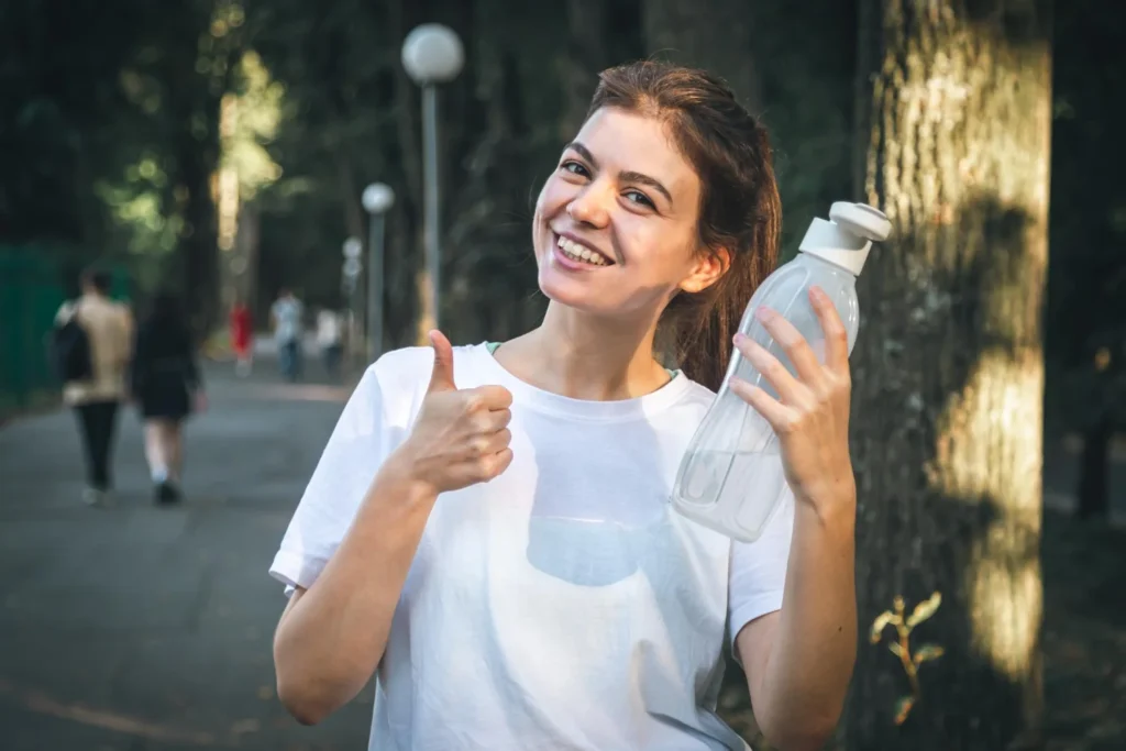 Woman drinking water to eliminate cellulite and improve skin health